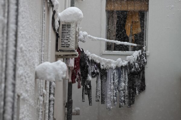 Unas ropas congeladas cuelgan de un tendedero del lado de fuera de la ventana de un apartamento en Madrid. - Sputnik Mundo