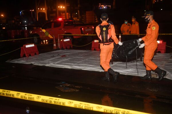Los miembros del equipo de rescate cargan una bolsa para cadáveres, en la que se supone que se encuentran los restos de los pasajeros del vuelo SJY182 de Sriwijaya Air. - Sputnik Mundo