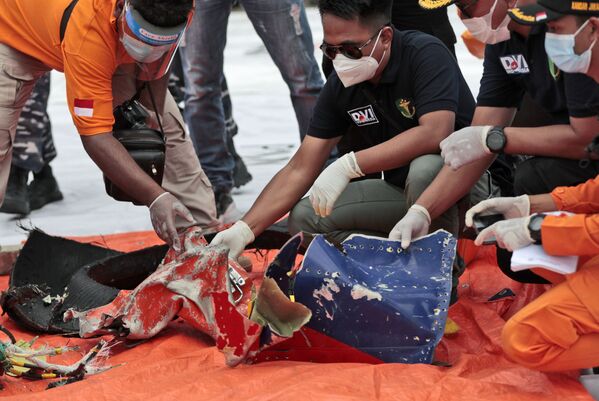 Los investigadores inspeccionan los escombros encontrados en las aguas de la isla de Java cerca de donde se estrelló el avión de pasajeros de Sriwijaya Air. - Sputnik Mundo