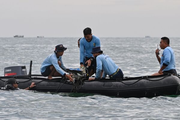 Buzos de la Armada de Indonesia recogen lo que se cree que son los restos del avión de Sriwijaya Air durante la operación de búsqueda y rescate en el mar cerca de la isla de Lancang, el 10 de enero. - Sputnik Mundo