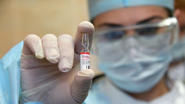 Una profesional de la salud sostiene una dosis de Sputnik V, una de las vacunas rusas contra el COVID-19 - Sputnik Mundo