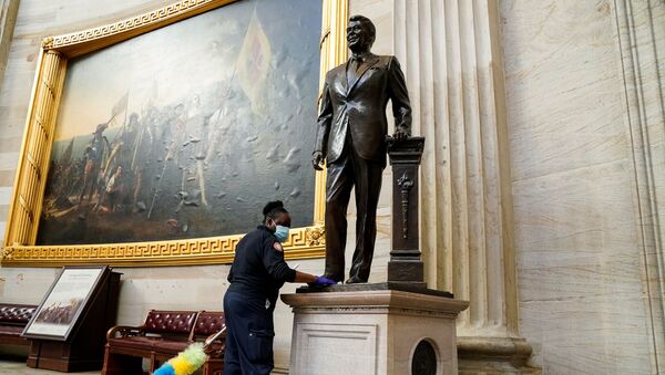 Una empleada del Capitolio limpia una estatua del expresidente Ronald Reagan ubicada en el interior de la Rotonda del Capitolio - Sputnik Mundo