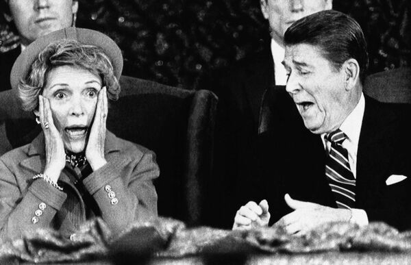 El día de la segunda toma de posesión de Reagan, el 21 de enero de 1985, la temperatura en Washington bajó a —14 °C, algo atípico para la capital estadounidense. A raíz del frío, Reagan prestó juramento en el interior del Capitolio y el desfile de investidura fue cancelado.En la foto: el presidente Ronald Reagan y su esposa, Nancy Reagan, reaccionan después de que la primera dama se sentara tras un discurso y se olvidara de presentar al presidente, durante un evento realizado para aquellos que habrían participado en el desfile inaugural cancelado por el mal tiempo. - Sputnik Mundo