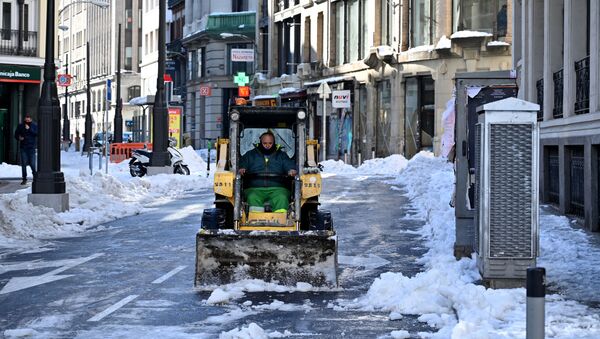 Un operario quita la nieve de la calzada en una céntrica calle de Madrid - Sputnik Mundo