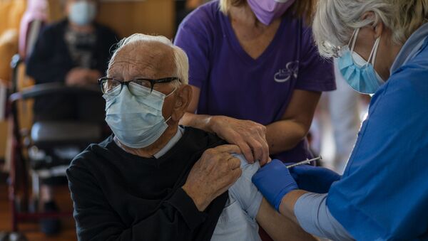 Una enfermera administra la vacuna Pfizer-BioNTech COVID-19 a un anciana en Barcelona - Sputnik Mundo