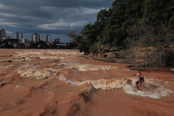 El surfista Paulo Guido en el río Doce, ubicado en el municipio Governador Valadares en Brasil, cuyo nivel de agua subió significativamente durante la temporada de lluvias. - Sputnik Mundo