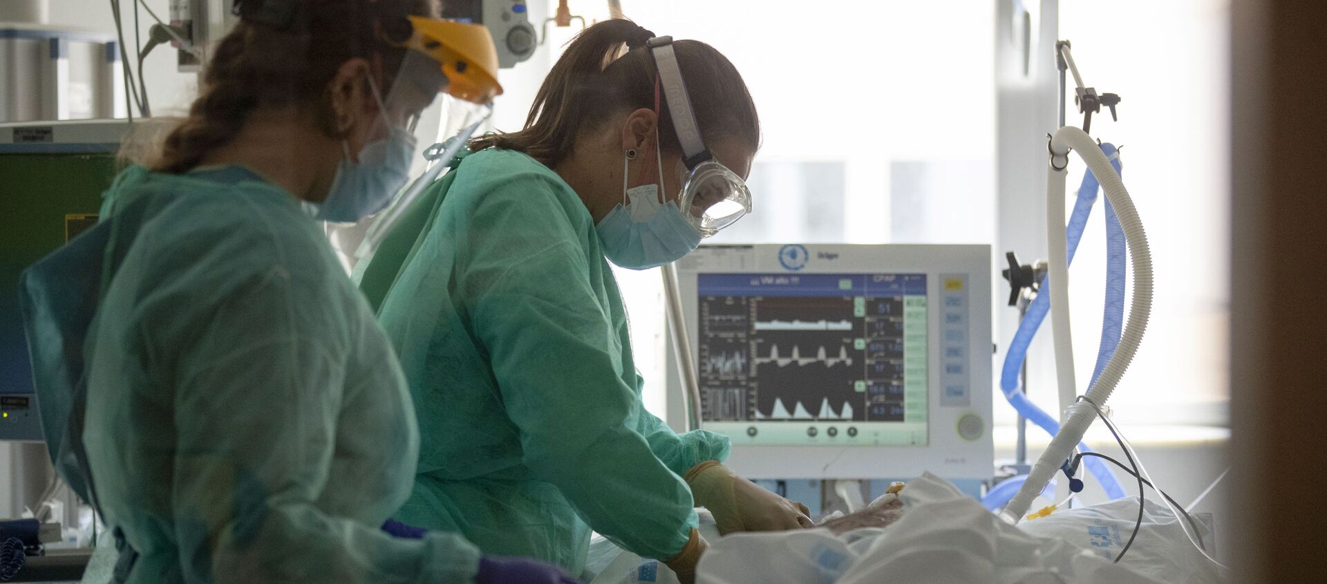 Trabajadores sanitarios asisten a un paciente con COVID-19 en una de las unidades de cuidados intensivos (UCI) del Hospital Universitario de Torrejón - Sputnik Mundo, 1920, 18.01.2021