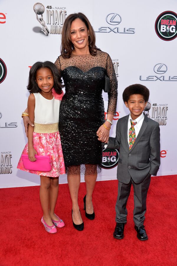 En los eventos sociales, se puede ver a Kamala Harris usando vestidos elegantes, más a menudo monocromáticos.En la foto: la fiscal general de California, Kamala Harris, con los invitados en la 45 edición de NAACP Image Awards en Pasadena, 2014.   - Sputnik Mundo