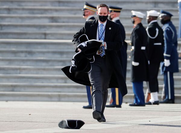 Funcionarios de la Administración recogen los sombreros caídos tras la toma de posesión del 46 presidente de Estados Unidos, Joe Biden.   - Sputnik Mundo