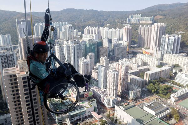 El alpinista Lai Chi-wai, que padece una parálisis de las extremidades inferiores, intenta escalar la torre Nina en Hong Kong. - Sputnik Mundo
