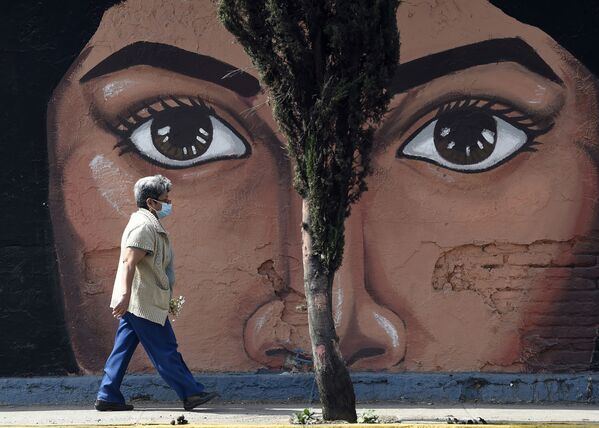 Una mujer pasa cerca del grafiti de una de las paredes del cementerio San Nicolás Tolentino en el municipio Iztapalapa, en México.  - Sputnik Mundo