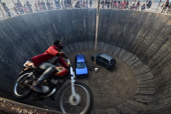Un doble de acción realiza un truco en el espectáculo 'Pared de la Muerte' en una feria en Allahabad, India. - Sputnik Mundo