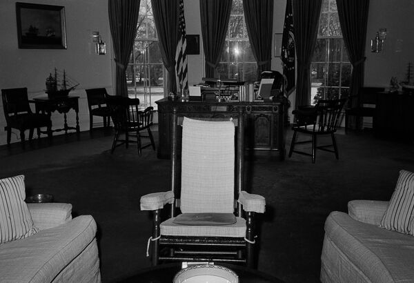 El escritorio Resolute, el más frecuentemente seleccionado por los presidentes, fue un regalo de la reina Victoria en 1880. El mueble se fabricó a partir de la madera de un buque británico llamado el HMS Resolute. Durante el mandato de John Kennedy, la primera dama, Jacqueline, se encargó de restaurar el escritorio.En la foto: la mecedora de Kennedy en la Oficina Oval de la Casa Blanca, en primer plano; al fondo, el escritorio Resolute (1962). - Sputnik Mundo