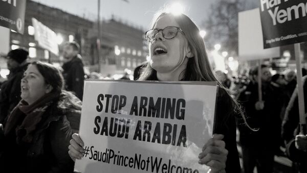 Una activista con un letrero de que pide dejar de armar a Arabia Saudí (archivo) - Sputnik Mundo
