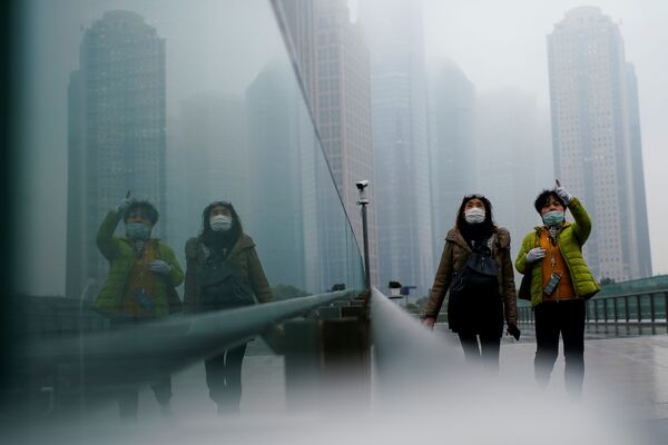 Personas con mascarillas en una calle de la ciudad china de Shanghái.  - Sputnik Mundo
