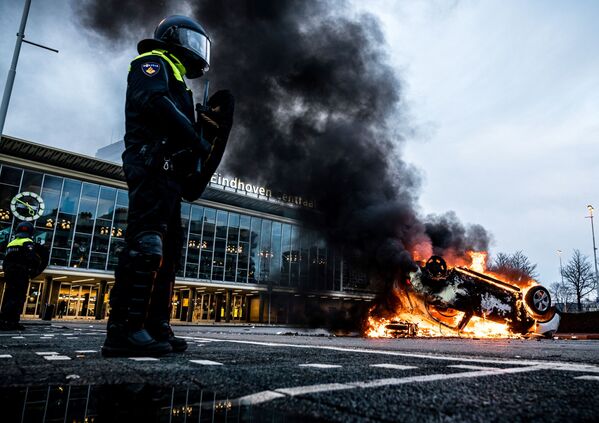 Los activistas prenden fuego a un coche durante una manifestación contra las restricciones por el COVID-19 en Eindhoven, los Países Bajos. - Sputnik Mundo