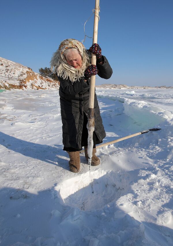 Cuando en los años 1950 comenzó la construcción de la central hidroeléctrica de Irkutsk, en el río Angará, que sale del lago Baikal, los habitantes del pueblo recibieron otras viviendas, pero la familia de Lubov Morejódova decidió no abandonar su hogar. En la foto: Lubov Morejódova martilla el hielo para obtener agua del lago Baikal - Sputnik Mundo