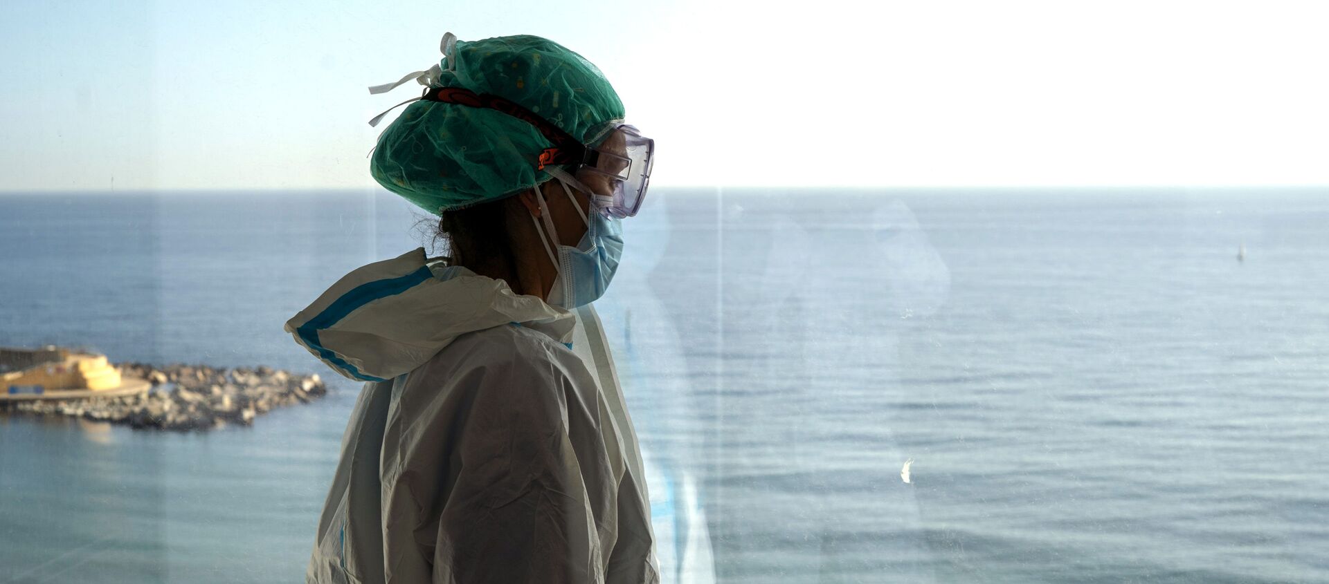 La enfermera Marta Fernández mira el mar desde una ventana durante un breve descanso en la sala COVID-19 del hospital del Mar en Barcelona - Sputnik Mundo, 1920, 02.02.2021