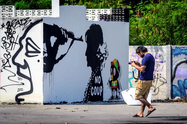 Un hombre toma una foto de un grafiti que representa a Aung San Suu Kyi en Bangkok (Tailandia). - Sputnik Mundo