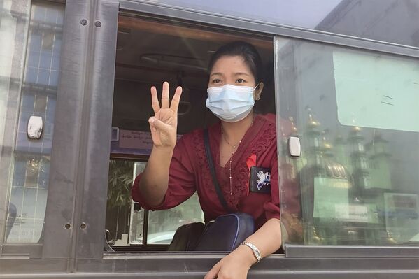 Una mujer expresa su solidaridad con los manifestantes contra el golpe militar en Birmania desde la ventana de un autobús en Rangún. - Sputnik Mundo