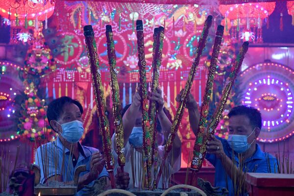 Los creyentes con palitos aromatizantes en un templo durante el Año Nuevo lunar en Ta Khmau, Camboya. - Sputnik Mundo