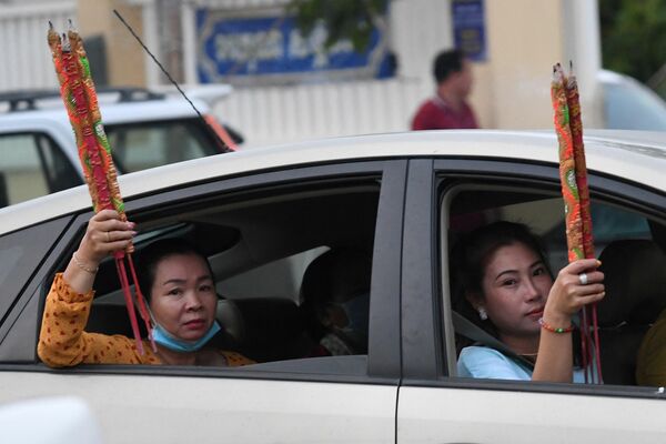 Unas mujeres con palitos aromatizantes en un coche durante la celebración del Año Nuevo lunar en Ta Khmau, Camboya. - Sputnik Mundo