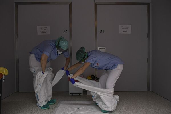 Profesionales de la salud se quitan la ropa protectora en una sala del hospital San Juan de Dios en Pamplona (España).  - Sputnik Mundo