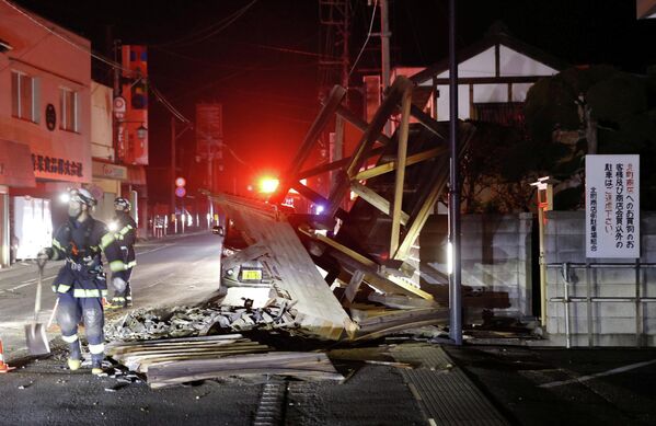 Miembros de los servicios de emergencia retiran los escombros de una construcción dañada en la ciudad de Koori, en Fukushima, tras el sismo. - Sputnik Mundo