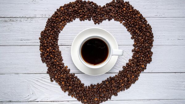 Una taza de café con granos en forma de corazón - Sputnik Mundo