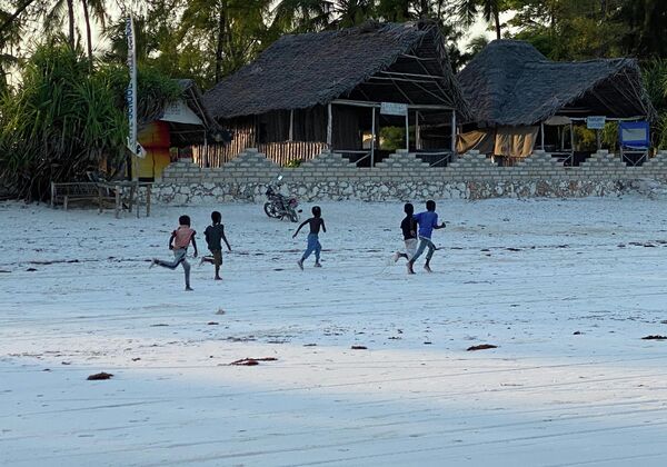 Unos niños corren por una playa de un pueblo pesquero zanzibarí. - Sputnik Mundo