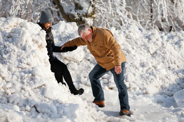 Los visitantes se ayudan el uno al otro para cruzar el hielo acumulado en el Parque Nacional de la ciudad de Niagara Falls debido a bajas temperaturas, Nueva York, EEUU. - Sputnik Mundo