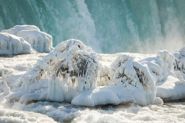 El agua corre alrededor del hielo en la cima de la catarata Horseshoe debido a las bajas temperaturas en la ciudad de Niagara Falls, Nueva York, EEUU. - Sputnik Mundo
