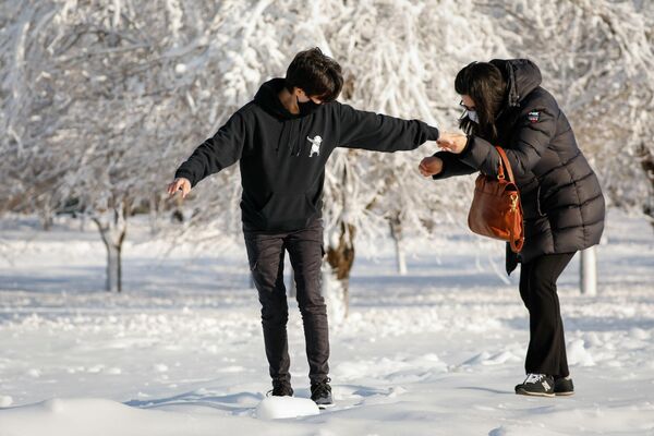 Los visitantes se ayudan entre sí para cruzar el hielo en el Parque Nacional de la ciudad de Niagara Falls debido a bajas temperaturas en Nueva York, EEUU. - Sputnik Mundo