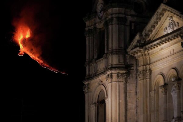 El monte Etna continúa en erupción emitiendo lava al rojo vivo y decora el cielo nocturno de la localidad de Zafferana Etnea, región de Sicilia, el 21 de febrero. - Sputnik Mundo