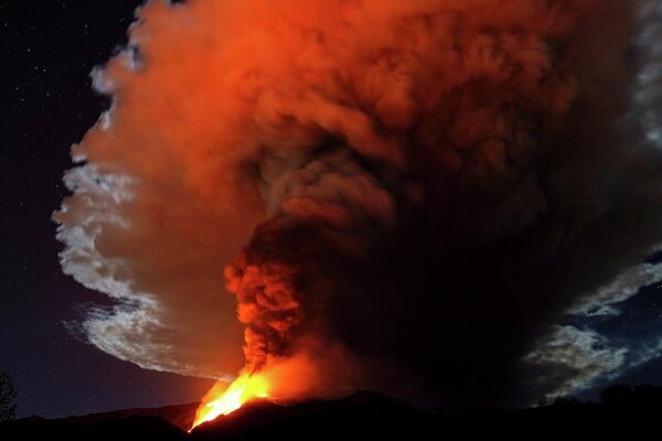 Enormes corrientes de lava al rojo vivo del Etna se lanzan al cielo nocturno de Italia. El volcán arrojó una enorme columna de humo y cenizas de más de un kilómetro de altura. - Sputnik Mundo
