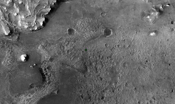 Un punto verde marca el lugar donde el Perseverance aterrizó en el cráter Jezero en Marte el 18 de febrero de 2021. La imagen fue tomada por la cámara HiRISE a bordo del orbitador de reconocimiento Mars Reconnaissance Orbiter de la NASA. - Sputnik Mundo