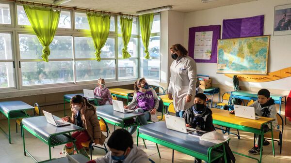 Niños utilizando mascarilla dentro de un salón de una escuela de Montevideo, durante el año 2020 - Sputnik Mundo