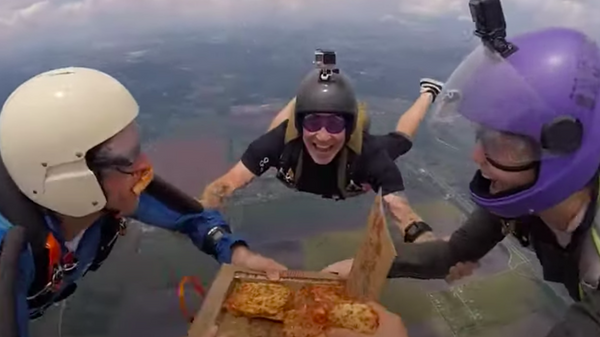 Unos paracaidistas comen una pizza mientras caen de más de 4.000 metros - Sputnik Mundo