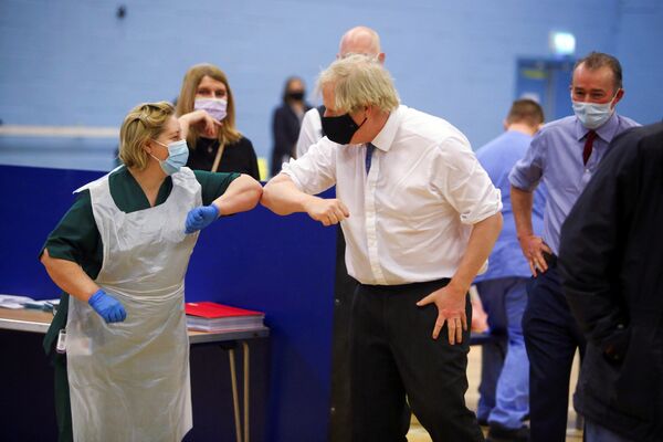 El primer ministro del Reino Unido, Boris Johnson, saluda a la enfermera Louise Gray durante una visita al centro de vacunación en Cwmbran, Gales del Sur. - Sputnik Mundo