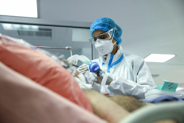 Una enfermera cuida a un paciente con COVID-19 en la UCI del hospital de Sotiria, en la capital de Grecia, Atenas. - Sputnik Mundo