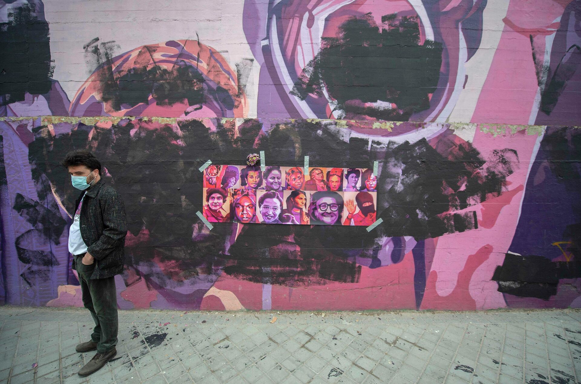 Un hombre pasa al lado del mural feminista que ha sido vandalizado.  - Sputnik Mundo, 1920, 08.03.2021