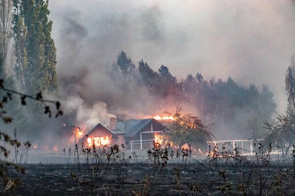 Al menos 250 casas y varios pueblos fueron afectados por los incendios. En la foto: una casa en llamas en Las Golondrinas, provincia de Chubut.  - Sputnik Mundo