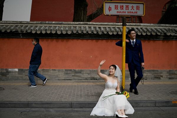 Recién casados durante una sesión de fotos frente a la Torre del Tambor en Pekín, China. - Sputnik Mundo