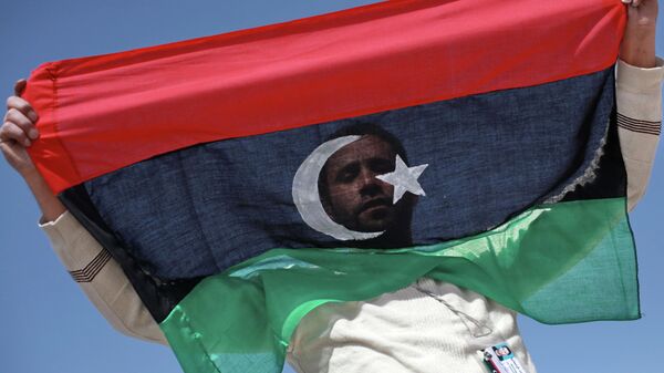 Un opositor con la bandera de Libia - Sputnik Mundo