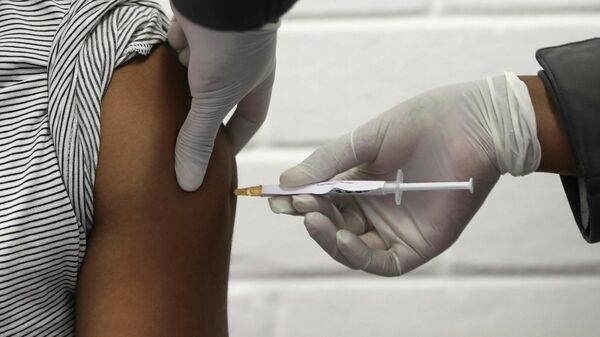 Un voluntario está siendo vacunado contra COVID-19 en Johannesburgo, Sudáfrica. - Sputnik Mundo
