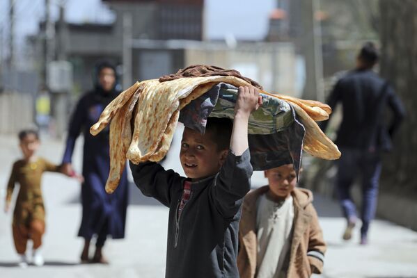 Un niño afgano lleva pan en la cabeza en una calle de Kabul, Afganistán. - Sputnik Mundo