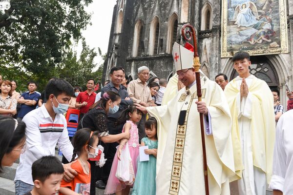 El obispo Joseph Vu Van Thien saluda a los fieles católicos tras celebrar una misa del Domingo de Pascua en la Catedral de San José en Hanói (Vietnam). - Sputnik Mundo