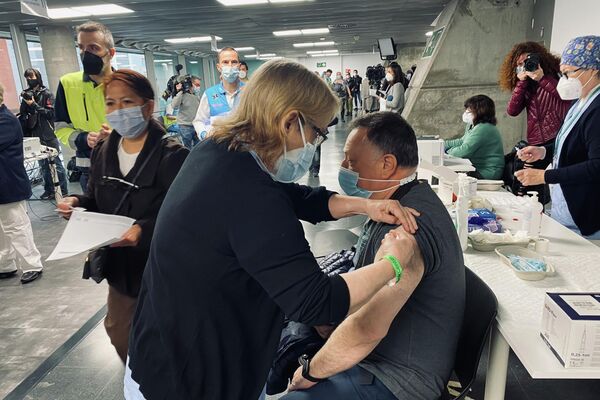 Un hombre se vacuna con la AstraZeneca en el WiZink Center de Madrid - Sputnik Mundo