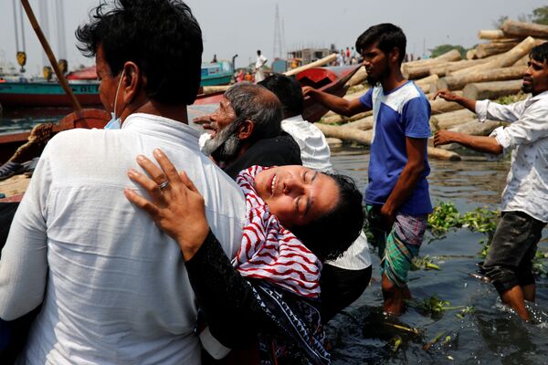 Familiares lloran después de que varias personas fallecieran en un accidente entre un ferry y un buque de carga en el río Shitalakhsyaa en Narayanganj, Bangladés. - Sputnik Mundo