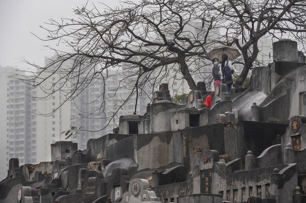 Unas mujeres rezan en un cementerio durante el Festival Ching Ming en Hong Kong (China), durante lo cual las personas visitan las tumbas de familiares fallecidos y dejan ofrendas en homenaje a su memoria. - Sputnik Mundo